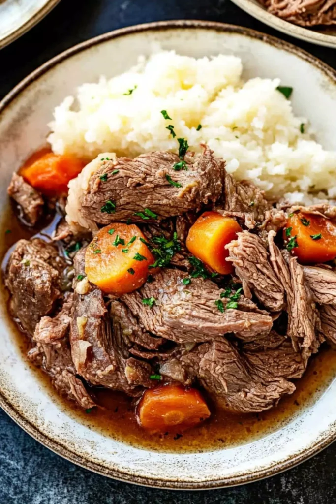 Classic Boneless Beef Chuck Roast Recipe 3 Plated boneless beef chuck roast with carrots and mashed potatoes topped with gravy