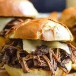 Shredded leftover beef chuck roast sandwich with Swiss cheese on a toasted French roll – a comforting and easy beef roast recipe.